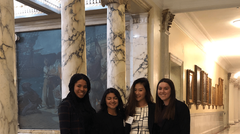 Four students pose for a photo inside the Massachusetts State House